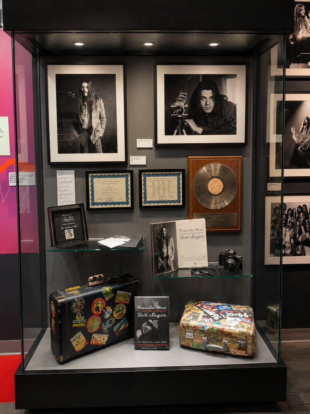 Travelin' Man exhibition display case with framed photography, archival materials, instruments, and tour objects